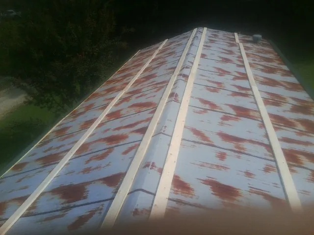 Rusted metal roof panels with new wood purlins before replacement — Storm Damage Roof Repair in Parmele by Roofing Brothers